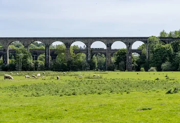 Historic viaduct with narrowboat canal boat on aqueduct arches stretching across a verdant landscape in Ceiriog valley in Chirk, Shropshire © steheap