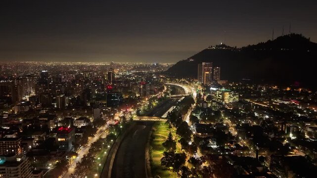 Aerial Horizontal Hyperlapse Flight Over Mapocho River, Providencia District and Cerro San Cristobal at Night, Santiago, Chile.
