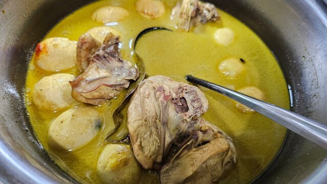 Opor ayam  in a round-bottomed cooking pan. Opor Ayam, Indonesian traditional chicken curry. Made from chicken cooked with coconut milk and various spices.