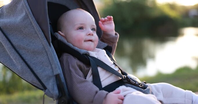 Cute little baby in stroller at park. Camera spinning