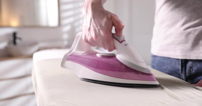 Man ironing shirt on board at home, closeup