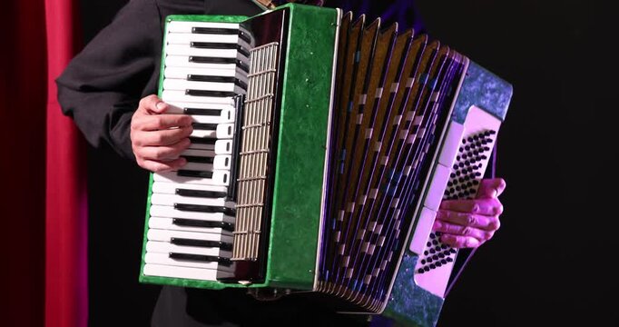 Man playing piano accordion on stage, closeup