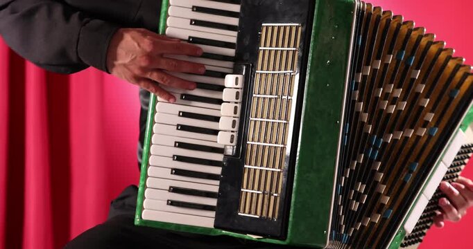Man playing piano accordion on stage, closeup
