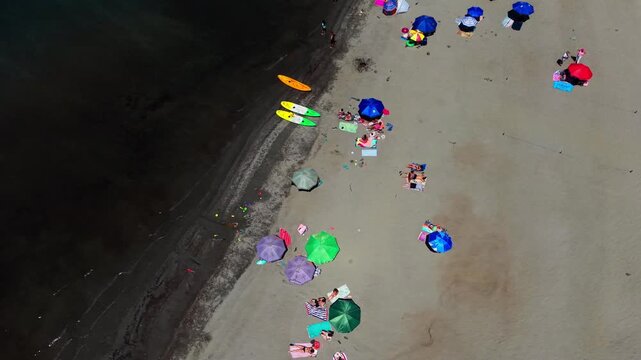 Aerial Vertical Panning Top Down View of People Sunbathing on a Crowded Sandy Beach, Chile