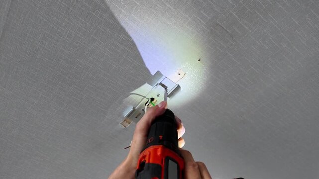 Person changing kitchen ceiling bulb. 