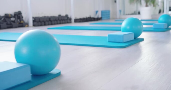 Camera is slowly panning from turquoise mat in studio, revealing blocks and balls for class prep