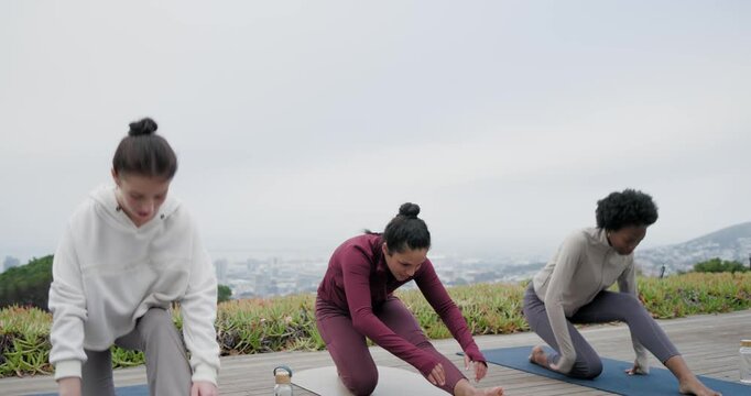Three women starting warmup, doing lunges then seated reach on deck with mats, bottles, high-fiving