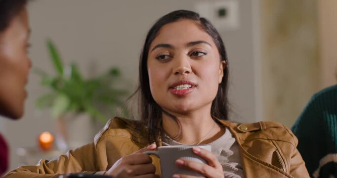 African-American friends' woman answering left gesture holding gray mug smiling laughing on couch