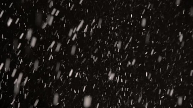 Snowflakes swirl and dance in a powerful snowstorm, contrasting vividly with the dark sky. This breathtaking moment captures the beauty of winter's fierce embrace