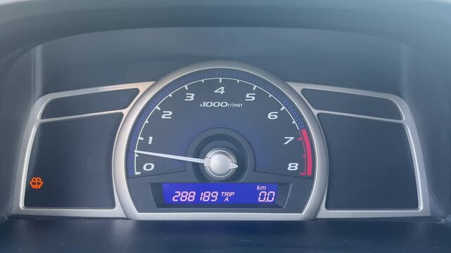 Car dashboard showing low windshield washer fluid warning light