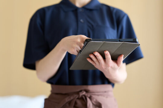 タブレットで仕事を管理する清掃業の女性