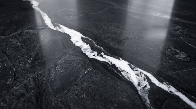 Abstract macro shot of a single white vein cutting through a dark black stone floor with minimalist contrast abstract monochrome interior background material architectural structure fracture