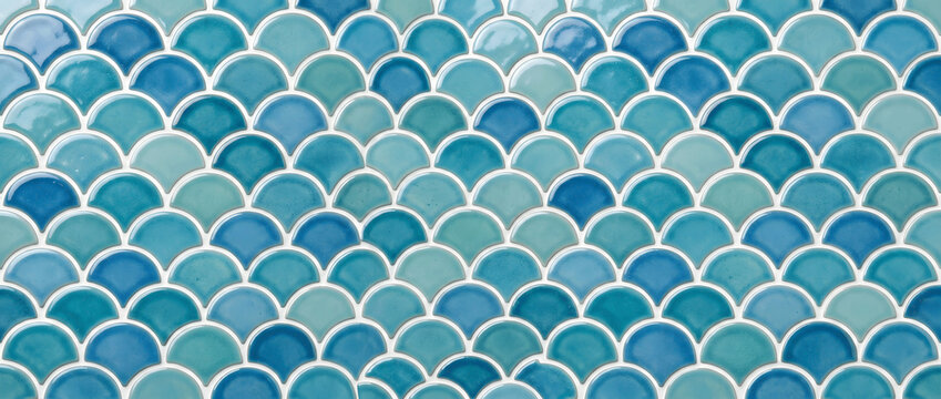Blue fish scale mosaic tile pattern with glossy ceramic texture creating a seamless coastal inspired background for elegant interiors