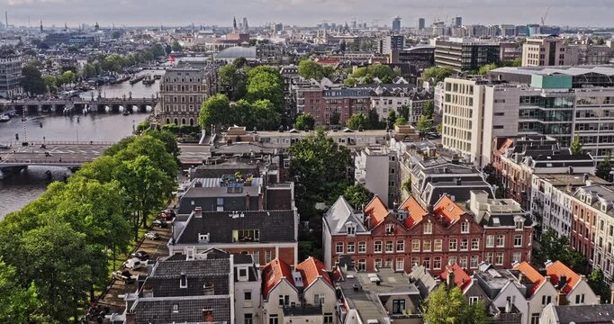 Amsterdam Netherlands Aerial v45 cinematic flyover weesperzijde and weesperbuurt en plantage neighborhoods along amstel river with cars traffic on the street and boats cruising on canal - August 2021