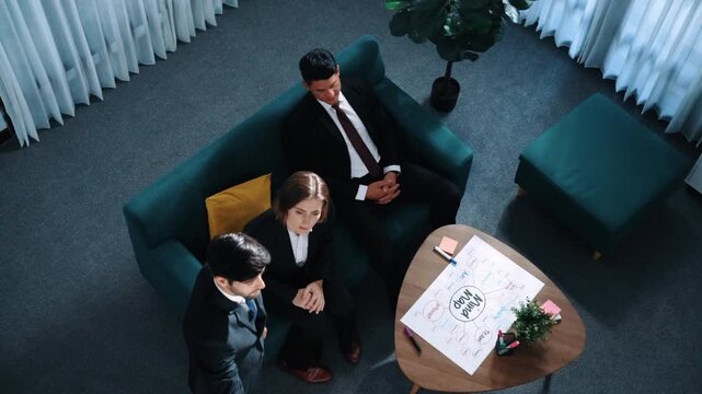 Top view of smart businessman present strategy to group of investor by using mind map brainstorm marketing idea at table with sticky notes and marker at meeting room. Creative workplace. Directorate.