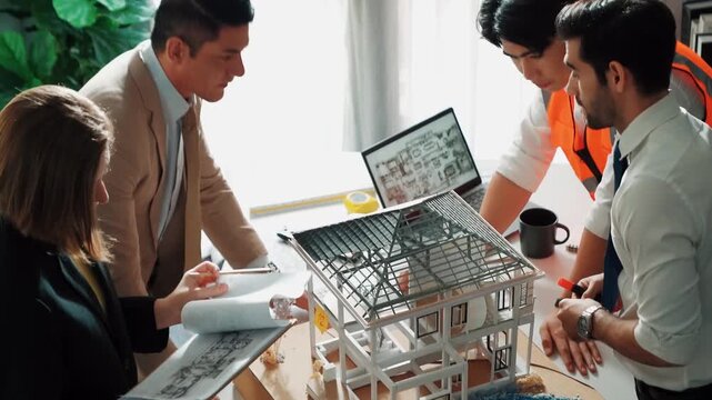 Top view of professional architect engineer team inspect house model while manager holding blueprint and asking about building construction. Group of diverse engineer working together. Alimentation.