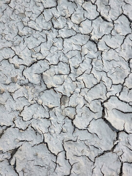 The surface of the earth was cracked by drought, cracks and erosion in the soil. Brown dry soil or cracked ground texture background. clay soil texture after water dry out and arid.

