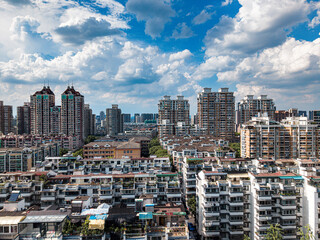 Fototapeta premium Aerial shot of Hangzhou city, West Lake and surrounding mountains framed under white clouds