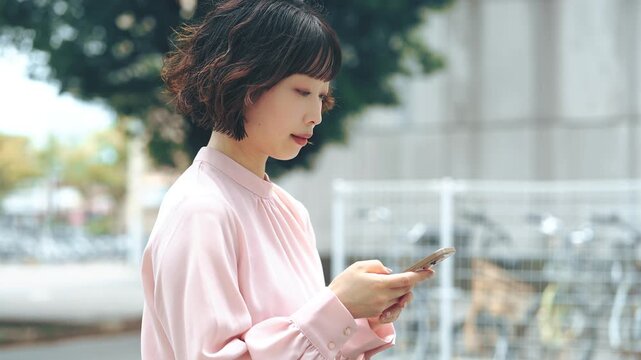 屋外でスマートフォンを使う女性・ビジネスウーマン, Businesswoman Using a Smartphone Outdoors