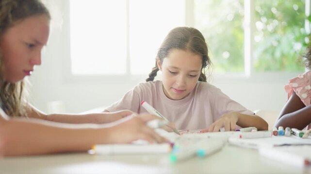 Group of Diverse school children creating arts and crafts together during creative classroom activity developing imagination teamwork fine motor skills and hands on learning in elementary education