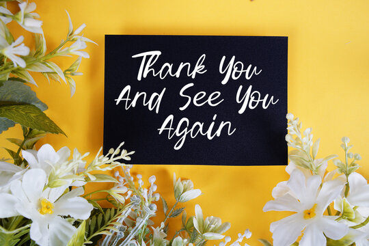 Thank You And See You Again text written on paper card with flowers decoration on blue background