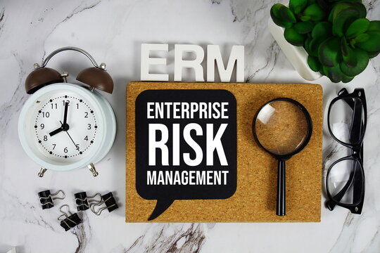 ERM - Enterprise Risk Management acronym with alarm clock and magnifying glass, business concept background