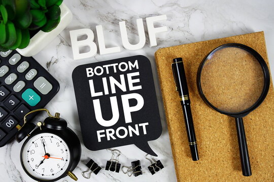 BLUF - Bottom Line Up Front acronym with calculator, alarm clock and magnifying glass, Business concept background