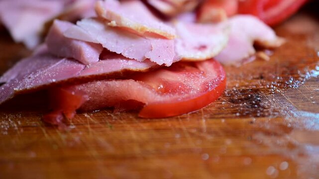 slicing ham cold cut meats cut tomato macro food background video, snacking on it, salt hands, picking up food