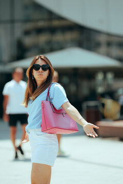 Confused Woman Wearing Sunglasses Holding Pink Bag On City Street. Lost  tourist with white shorts looks around bewildered trying find right direction
