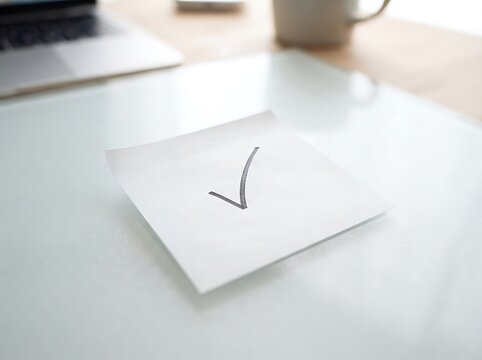 White sticky note with handwritten checkmark
