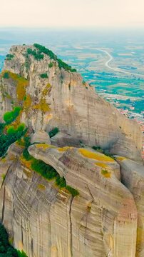Vertical video. Meteora, Kalabaka, Greece. Meteora - rocks, up to 600 meters high. There are 6 active Greek Orthodox monasteries listed on the UNESCO list. Drone footage, Point of interest. Rich colo