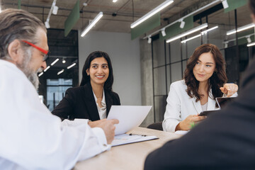 Naklejka premium Business professionals collaborating in a corporate meeting, diverse team discussing strategy in modern office