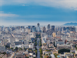 Fototapeta premium Aerial shot of Hangzhou city, West Lake and surrounding mountains framed under white clouds