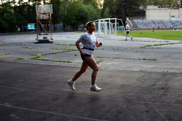 Obraz premium Adult European Woman Running in Open Stadium.