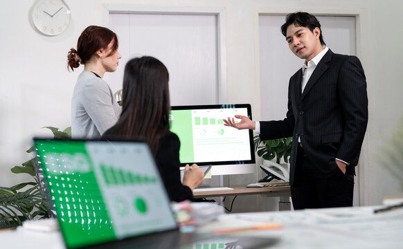 Asian businessman presenting ESG report on computer screen to his team.