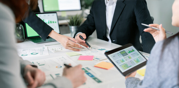 Business team collaborating on ESG and financial data in office.