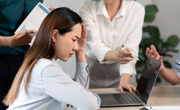 Stressed Asian businesswoman suffering from headache during a difficult meeting.