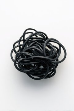 Black rubber bands tangled in a messy pile isolated on white background. Represents chaos and disorganization.