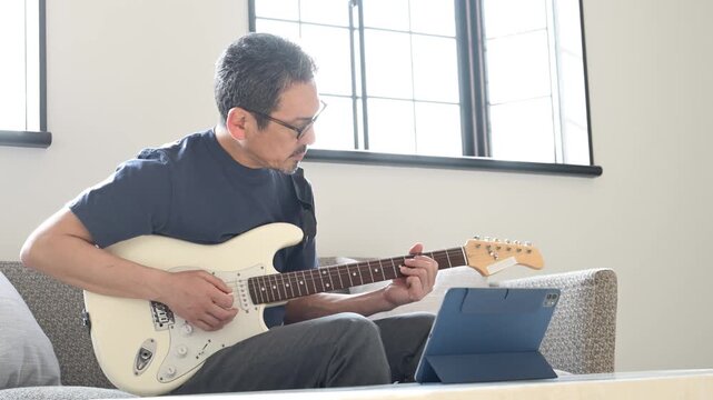 難しいフレーズの練習に真剣に取り組む50代の日本人男性