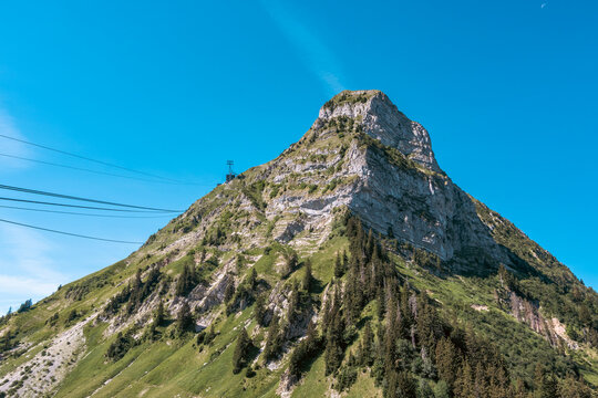 Le sommet rocheux du Mol&eacute;son et les c&acirc;bles du t&eacute;l&eacute;ph&eacute;rique sous un grand ciel bleu en &eacute;t&eacute;