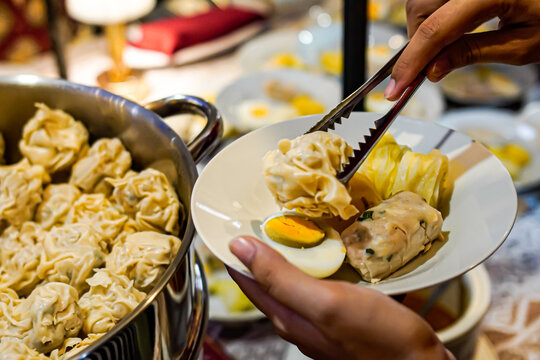 Indonesian siomay dumplings being served with tongs close up street food