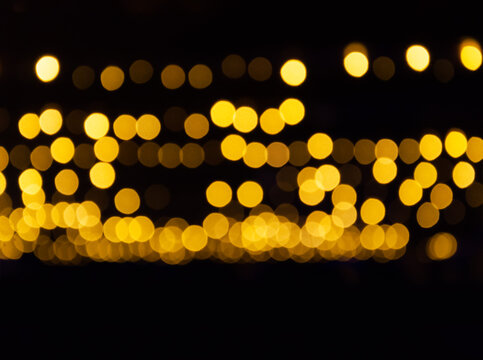 Bright circles fill the dark space. New Year's background in golden color