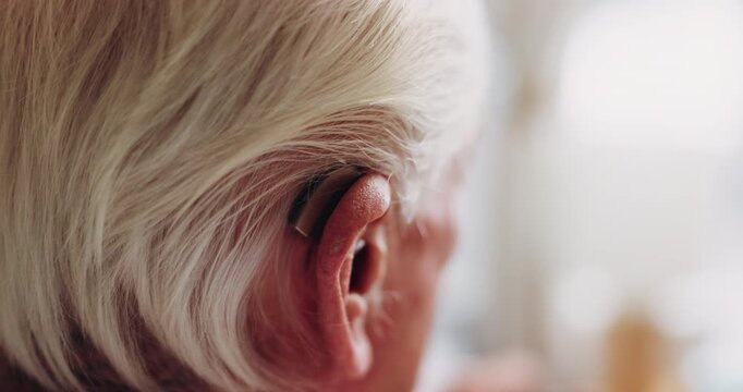 Senior, woman and ear with hearing aid for audio, sound or awareness for balance in house. Elderly, female person or retirement with medical senses for speech, noise or treatment in nursing home