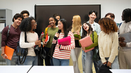 Fototapeta premium Group of multiethnic young adults smiling and talking in a modern college classroom