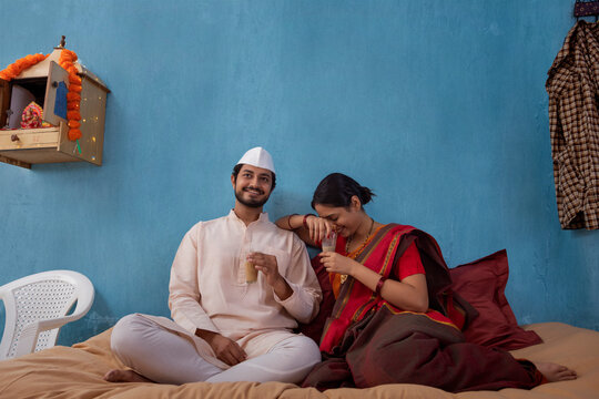 Maharashtrian couple having tea while sitting on cot at home