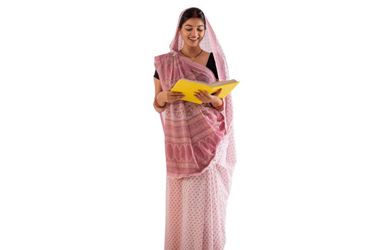 Portrait of a woman reading book while standing against white background