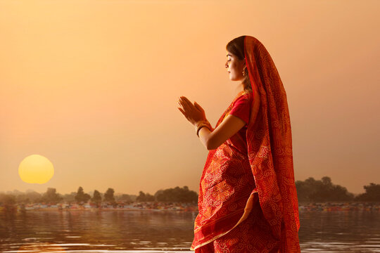 woman from Bihar offers prayers to the  sun  in the  early morning hours during  Chhath Puja festival