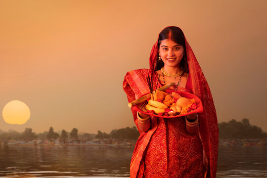 woman from Bihar offers prayers to the  sun  in the  early morning hours   during  Chhath Puja festival