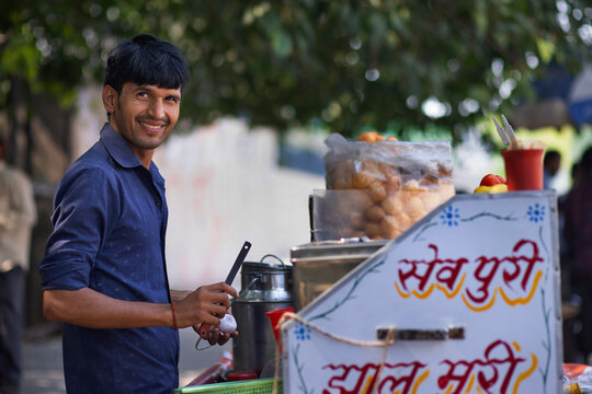 Portrait of a smiling male street vendor looking elsewhere