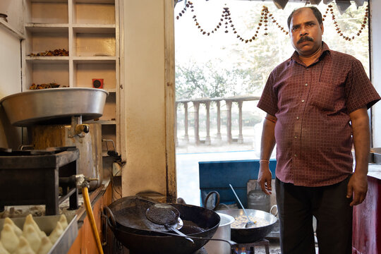 Owner of a sweet shop known as a Halwai  standing in the kitchen of his sweet   shop